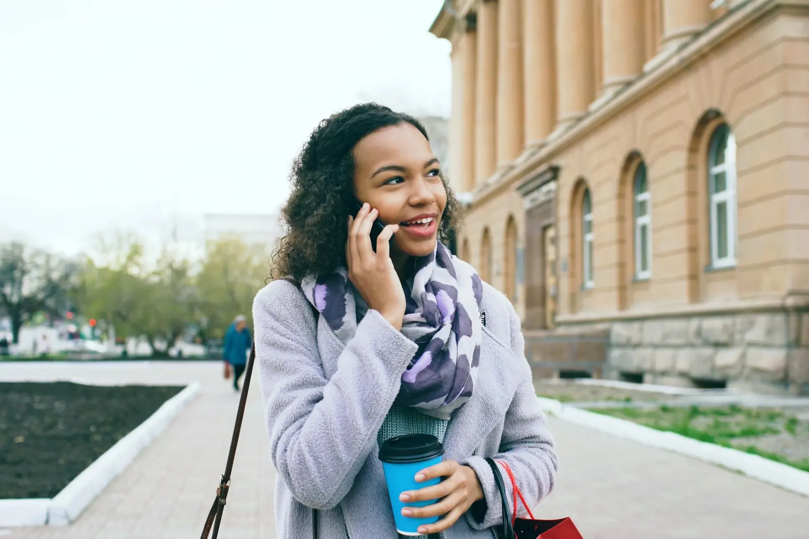 Entrepreneur on the phone while walking with a coffee